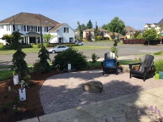 Side yard gravel seating area with Adirondack chairs and new plantings